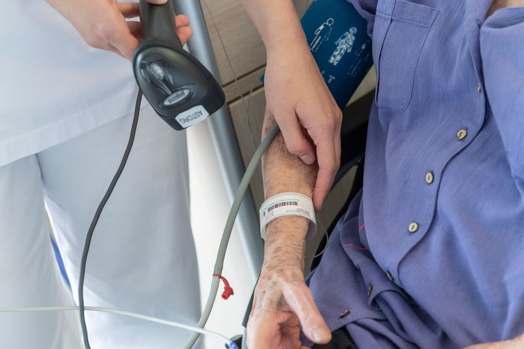 Photo illustrant une professionnelle de santé en train de scanner le bracelet d'identification d'une patiente de la clinique des minimes