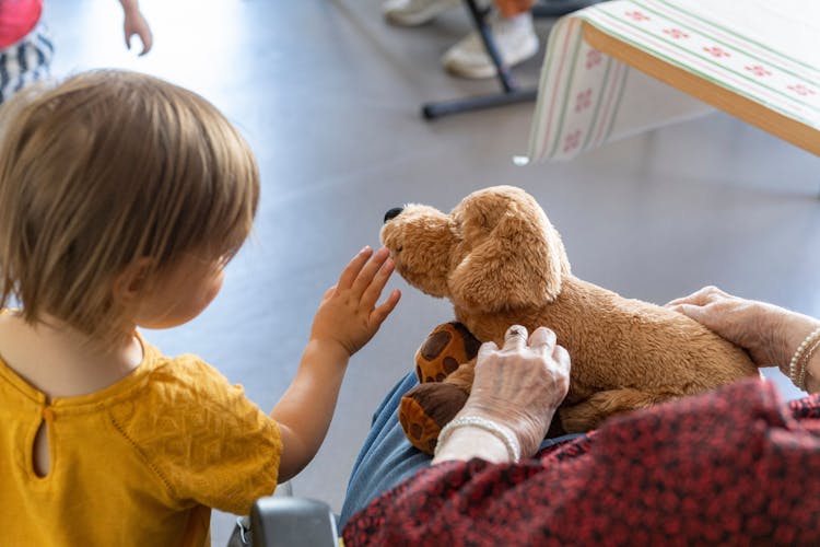 Photo illustrant une enfant tenant une peluche sur les genoux d'une patiente de la clinique des minimes